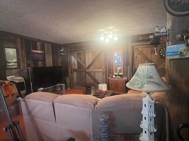 living room with a textured ceiling and wood walls