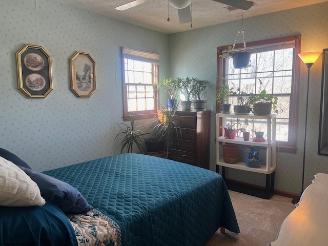 bedroom featuring ceiling fan, carpet floors, and a textured ceiling