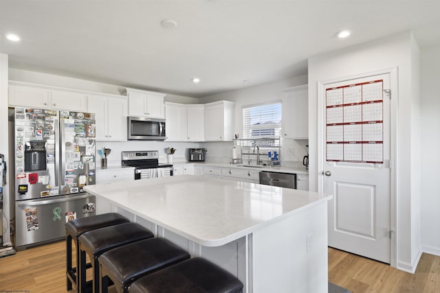 kitchen featuring white cabinetry, a breakfast bar area, stainless steel appliances, and a center island