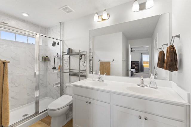 bathroom featuring walk in shower, ceiling fan, vanity, and toilet