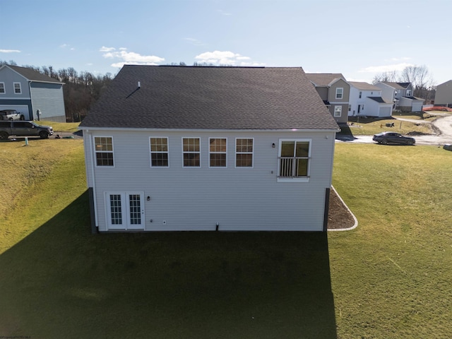 view of side of home with french doors and a yard