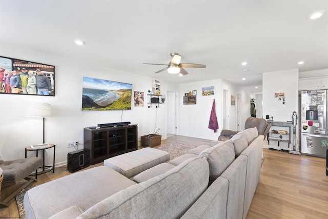 living room with ceiling fan and light hardwood / wood-style flooring