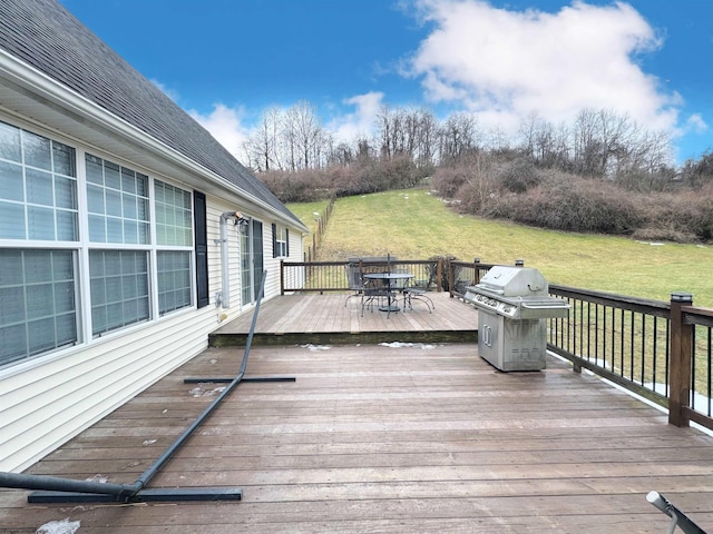 wooden deck featuring grilling area and a lawn