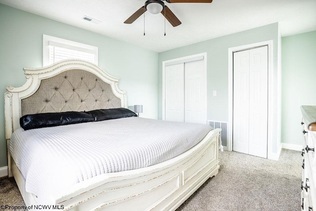 carpeted bedroom with multiple closets and ceiling fan