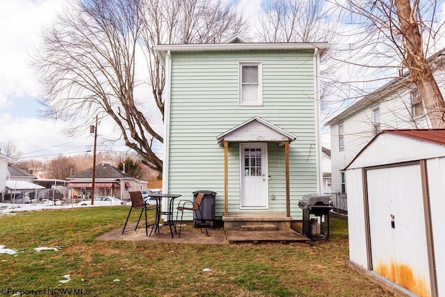 rear view of house with a shed and a yard