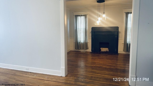 unfurnished living room featuring crown molding and dark hardwood / wood-style floors