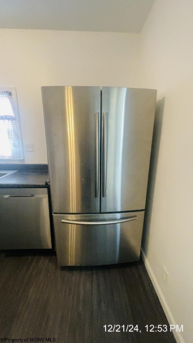 room details with dark wood-type flooring and appliances with stainless steel finishes