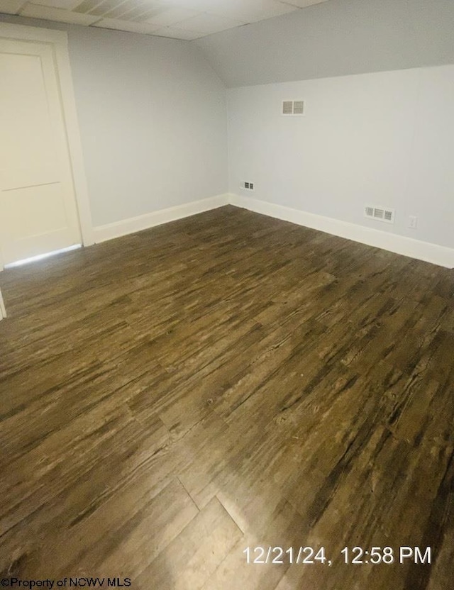 interior space featuring lofted ceiling and dark wood-type flooring