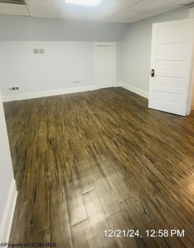 basement featuring dark hardwood / wood-style flooring and a paneled ceiling