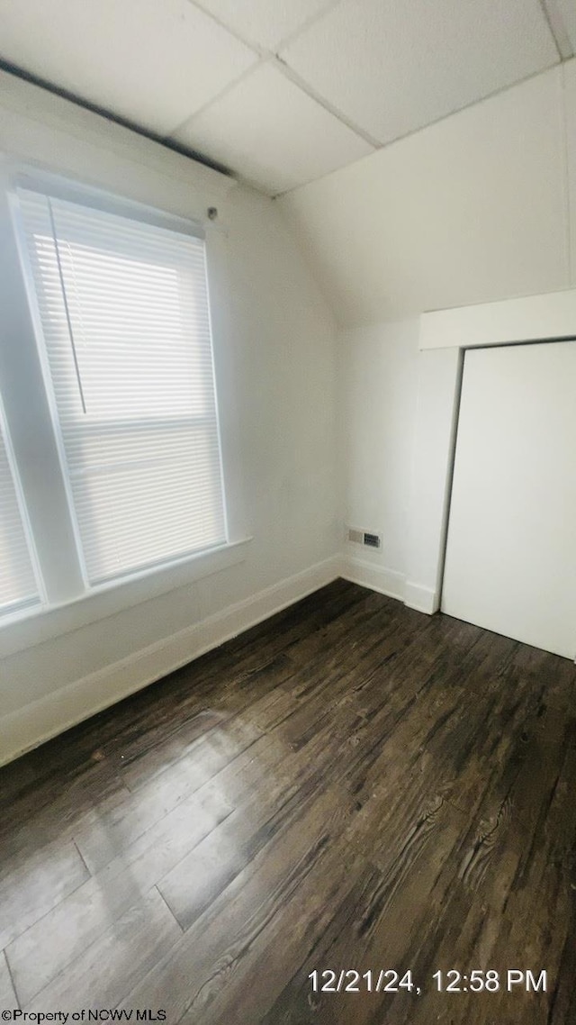 additional living space with dark hardwood / wood-style flooring and vaulted ceiling