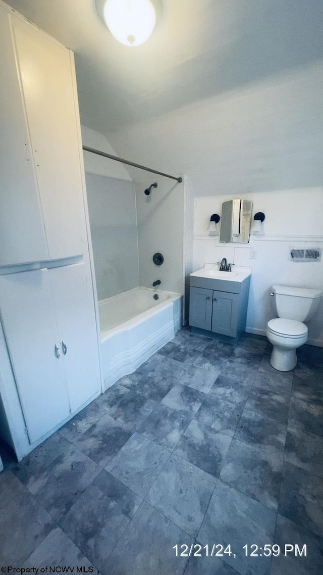 full bathroom featuring tiled shower / bath, vanity, and toilet