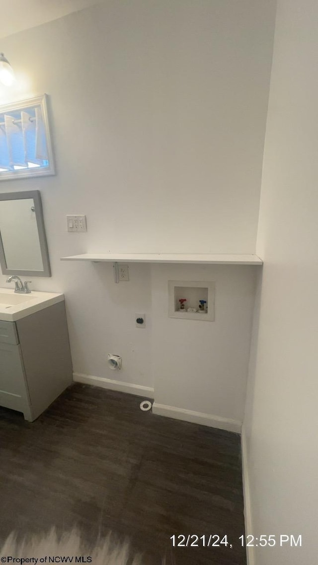 clothes washing area with dark hardwood / wood-style floors, sink, hookup for an electric dryer, and hookup for a washing machine