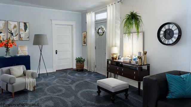 living area with ornamental molding and dark colored carpet