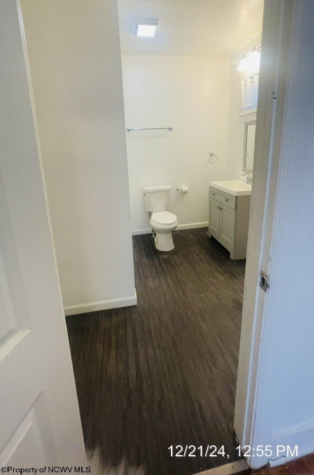 bathroom with hardwood / wood-style flooring, vanity, and toilet