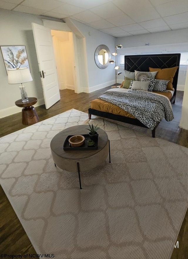 bedroom featuring wood-type flooring and a drop ceiling