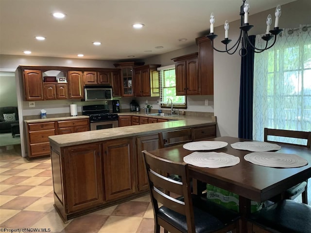 kitchen featuring sink, a notable chandelier, stainless steel appliances, and kitchen peninsula