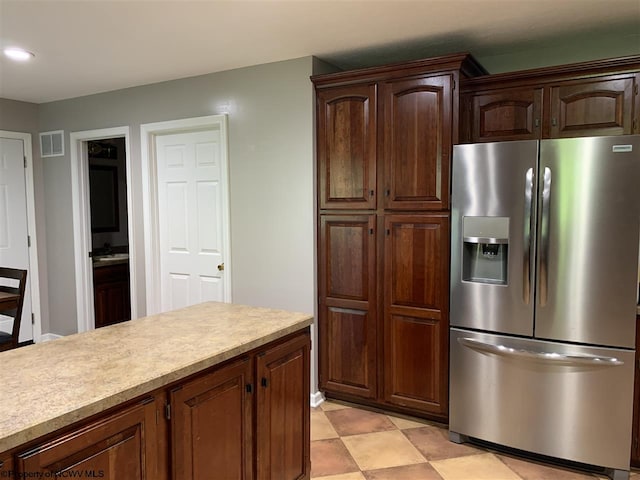 kitchen with dark brown cabinetry and stainless steel fridge with ice dispenser