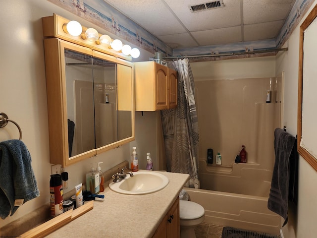 full bathroom featuring shower / bath combination with curtain, vanity, toilet, and a drop ceiling