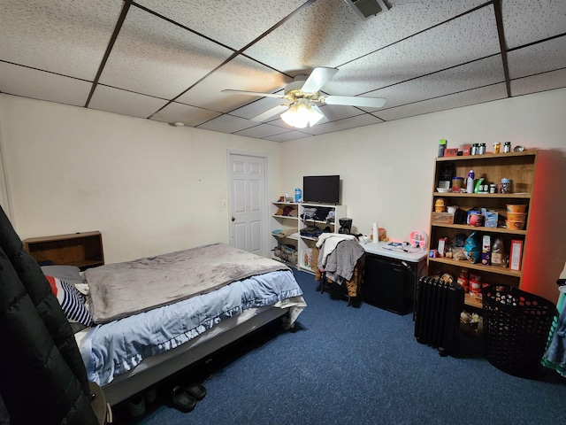 carpeted bedroom with a drop ceiling and ceiling fan