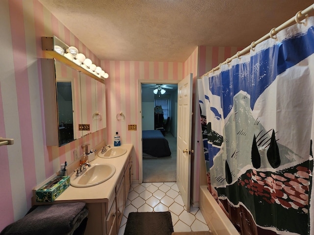 bathroom featuring ceiling fan, vanity, shower / tub combo, and a textured ceiling