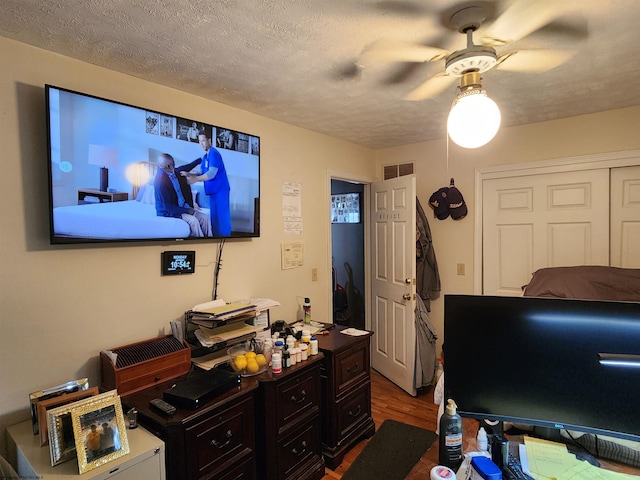 office with dark hardwood / wood-style flooring, ceiling fan, and a textured ceiling