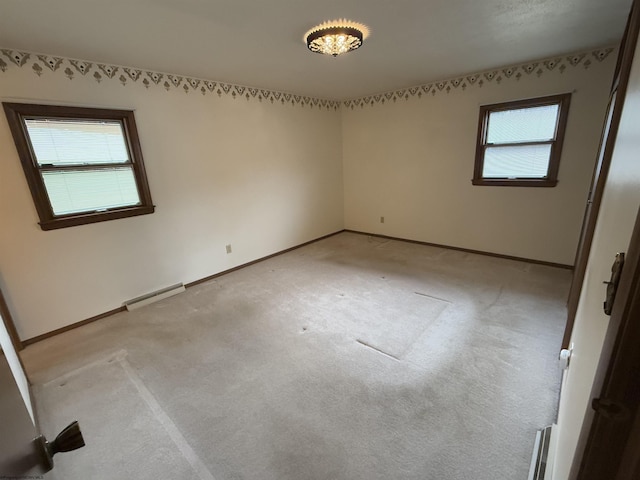 carpeted empty room with a baseboard heating unit