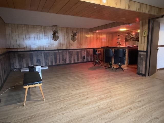 bar with wooden walls, light hardwood / wood-style floors, and wooden ceiling