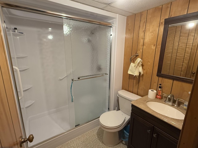 bathroom with vanity, an enclosed shower, wooden walls, and toilet