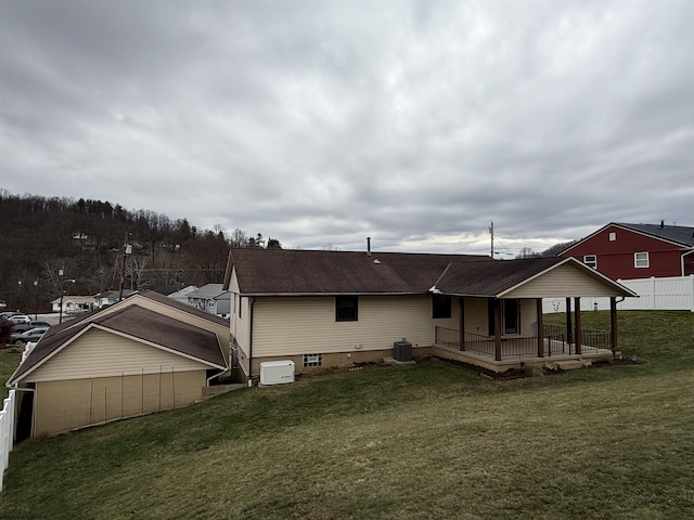 back of property featuring central AC unit and a lawn