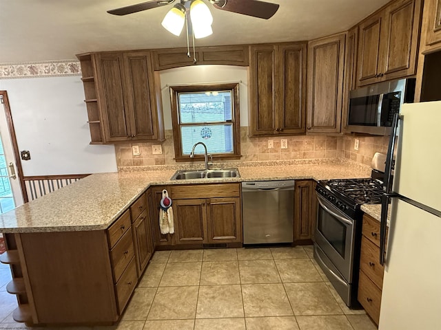 kitchen with tasteful backsplash, stainless steel appliances, kitchen peninsula, and sink