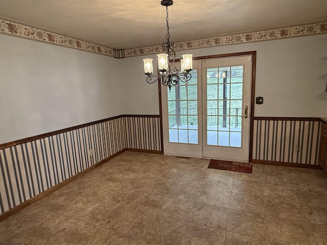 unfurnished dining area with a chandelier