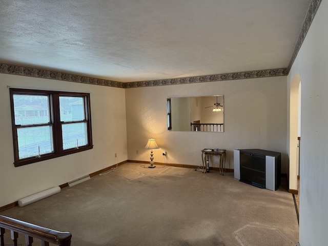 spare room featuring ceiling fan, a textured ceiling, and carpet