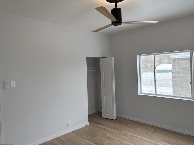 unfurnished bedroom with ceiling fan, light wood-type flooring, and a closet