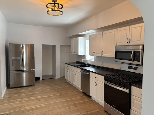 kitchen featuring sink, stainless steel appliances, white cabinets, and light wood-type flooring