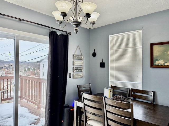 dining area featuring a notable chandelier and a textured ceiling