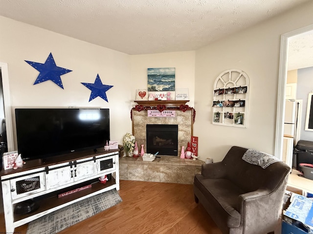 living room with a fireplace, wood-type flooring, and a textured ceiling