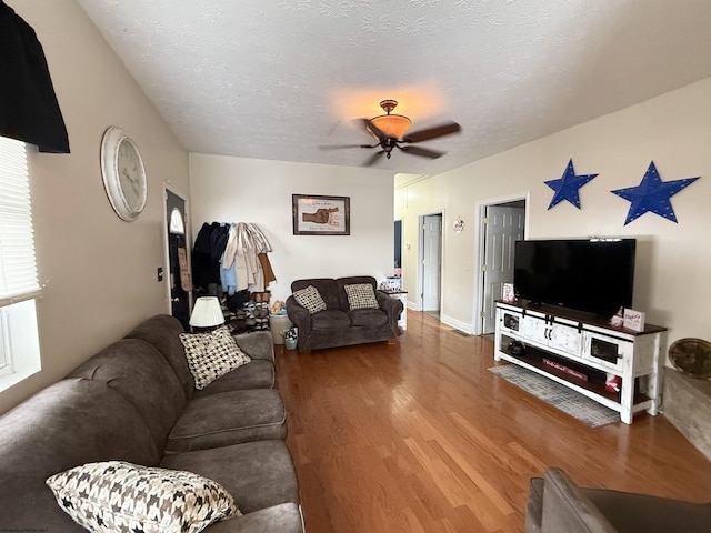 living room featuring hardwood / wood-style floors, a textured ceiling, and ceiling fan