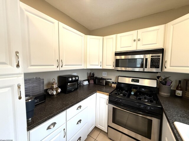 kitchen with white cabinetry and appliances with stainless steel finishes