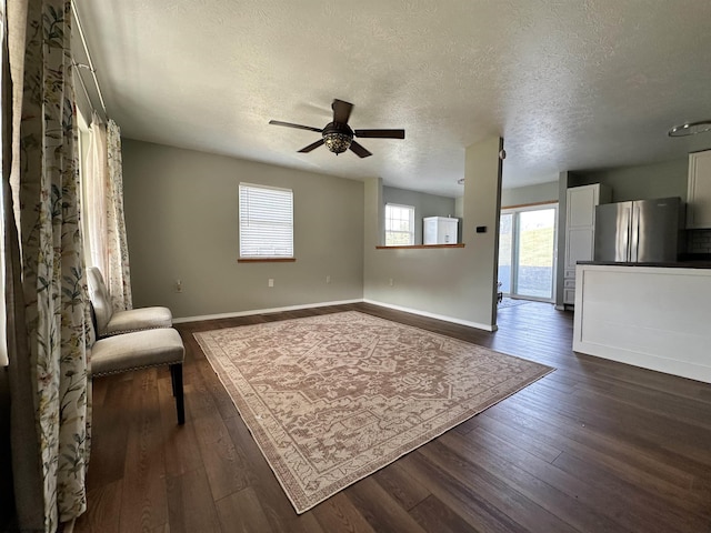 unfurnished room featuring ceiling fan, dark hardwood / wood-style floors, and a textured ceiling