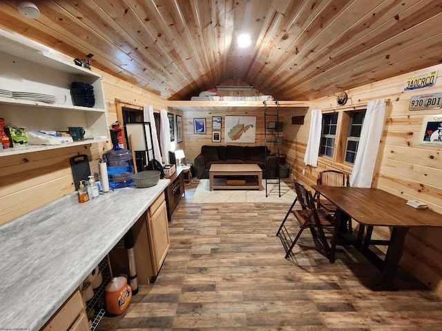 dining room featuring lofted ceiling, wooden walls, hardwood / wood-style floors, and wooden ceiling