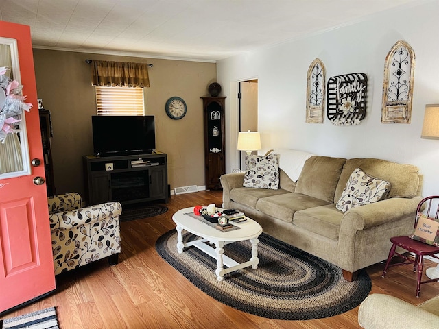 living room featuring crown molding and hardwood / wood-style flooring