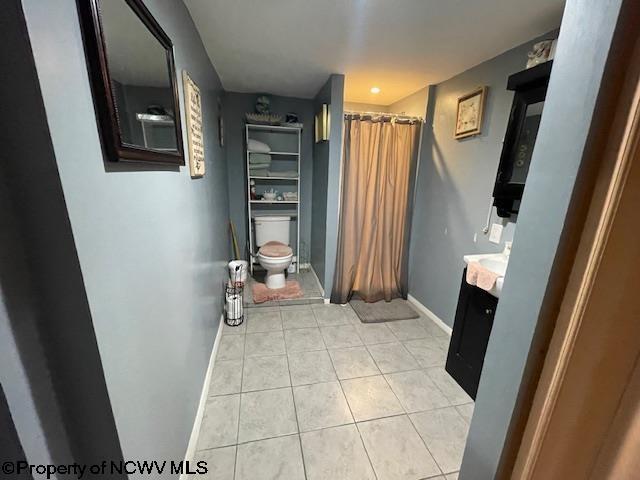 bathroom featuring vanity, toilet, and tile patterned flooring