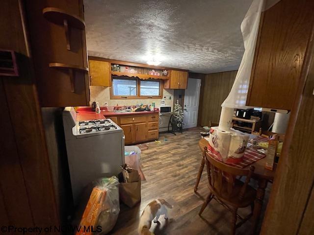 kitchen featuring hardwood / wood-style flooring, white range with gas cooktop, and a textured ceiling