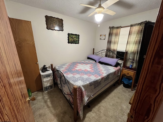 bedroom with ceiling fan, carpet flooring, and a textured ceiling