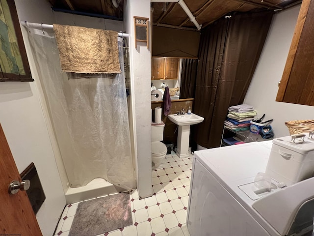 bathroom with walk in shower, independent washer and dryer, toilet, and sink