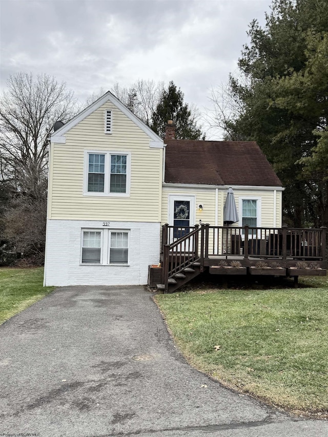 view of front of property featuring a wooden deck and a front lawn