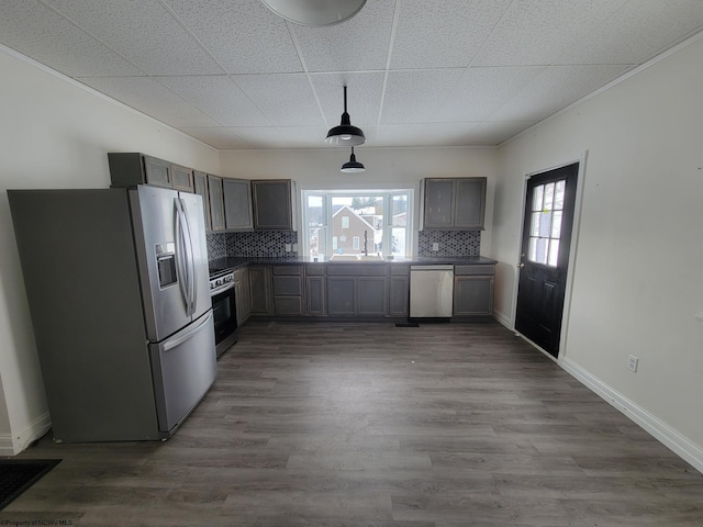 kitchen with stainless steel appliances, sink, hardwood / wood-style floors, and decorative backsplash