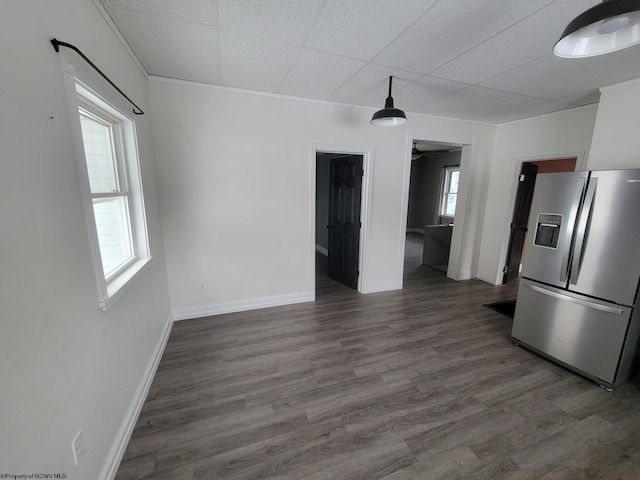 interior space with stainless steel fridge, ornamental molding, and dark hardwood / wood-style floors