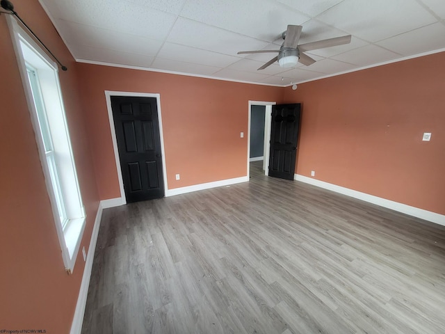 unfurnished room featuring crown molding, a drop ceiling, ceiling fan, and light wood-type flooring