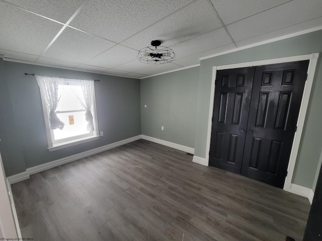 interior space with crown molding, ceiling fan, a drop ceiling, and dark hardwood / wood-style flooring